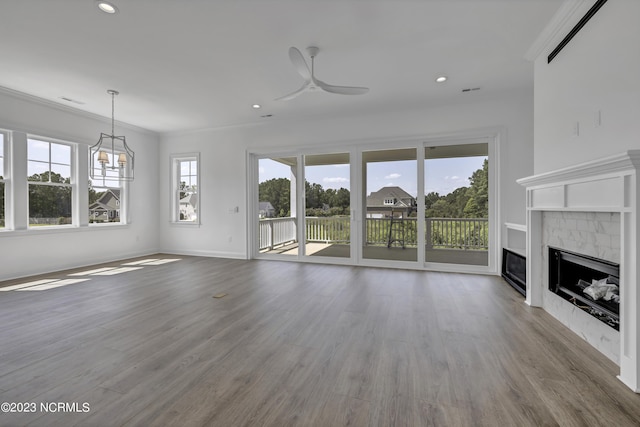 unfurnished living room with crown molding, wood finished floors, a ceiling fan, and a tile fireplace