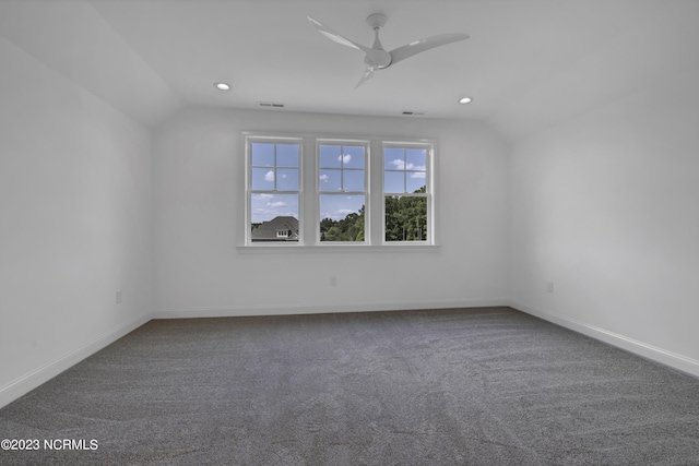 carpeted spare room featuring vaulted ceiling, a ceiling fan, visible vents, and baseboards