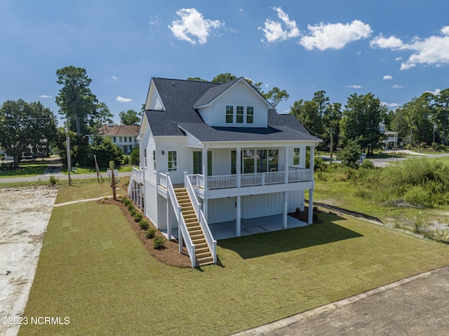 view of front facade featuring stairs, a front lawn, driveway, and roof with shingles