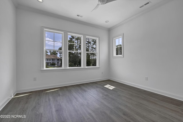 spare room featuring visible vents, baseboards, dark wood-type flooring, and crown molding