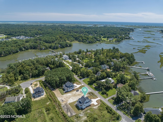 drone / aerial view with a water view and a wooded view