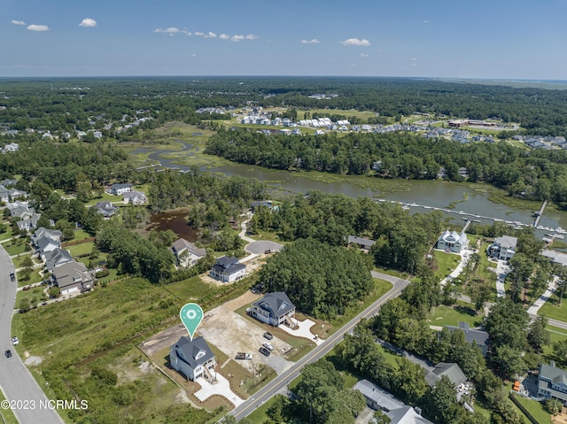 birds eye view of property with a water view and a view of trees