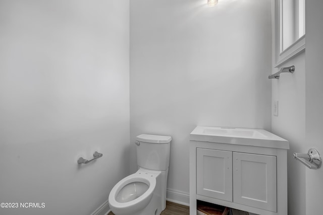 bathroom featuring vanity, toilet, and baseboards