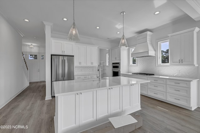 kitchen featuring a sink, appliances with stainless steel finishes, white cabinets, light countertops, and custom exhaust hood