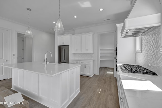 kitchen with custom exhaust hood, white cabinetry, high quality fridge, and ornamental molding