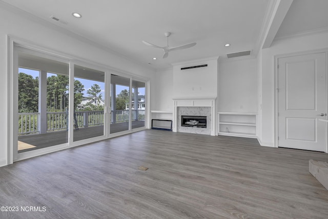 unfurnished living room with visible vents, wood finished floors, a ceiling fan, and ornamental molding