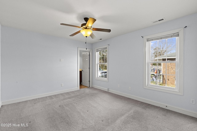 unfurnished room with visible vents, baseboards, carpet, and a healthy amount of sunlight