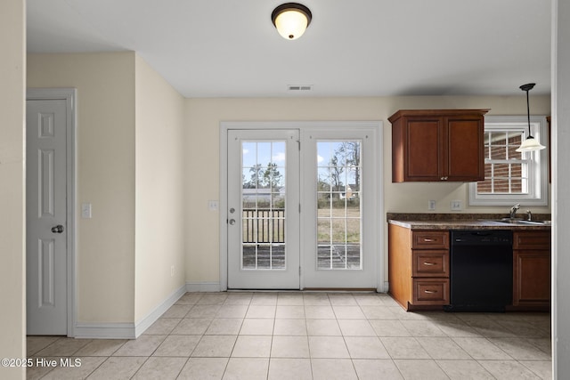 kitchen featuring baseboards, black dishwasher, light tile patterned floors, hanging light fixtures, and a sink