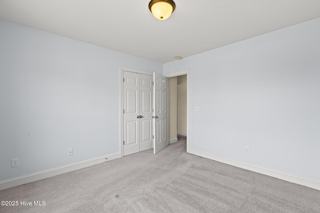 carpeted spare room featuring baseboards