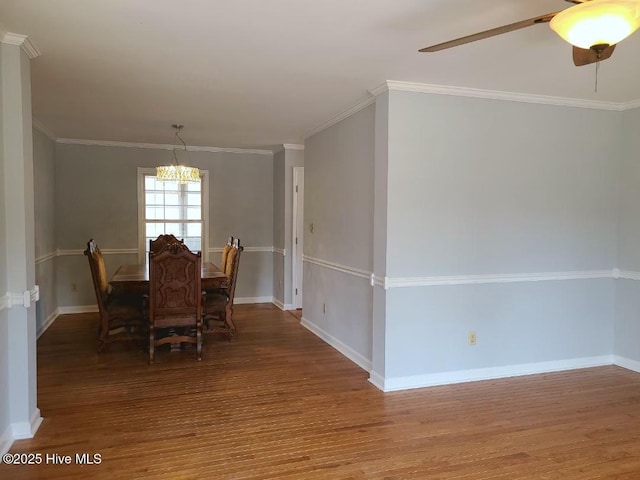 dining room with ceiling fan with notable chandelier, crown molding, baseboards, and wood finished floors