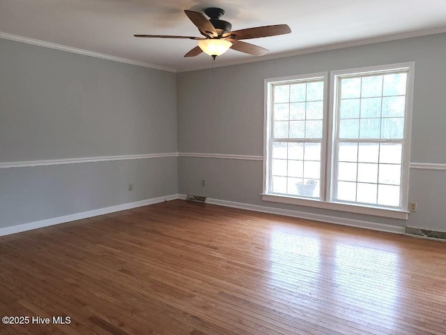 spare room with plenty of natural light, crown molding, ceiling fan, and wood-type flooring