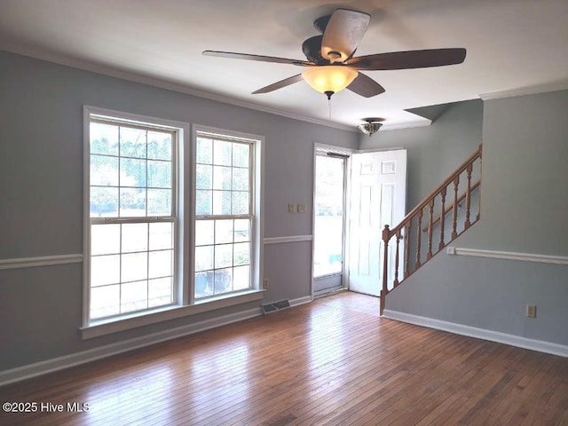 foyer with visible vents, stairway, wood-type flooring, crown molding, and baseboards