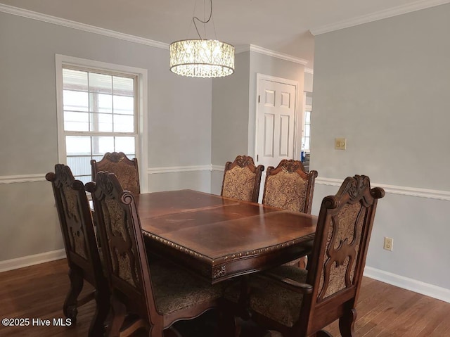 dining room with a notable chandelier, wood finished floors, baseboards, and ornamental molding