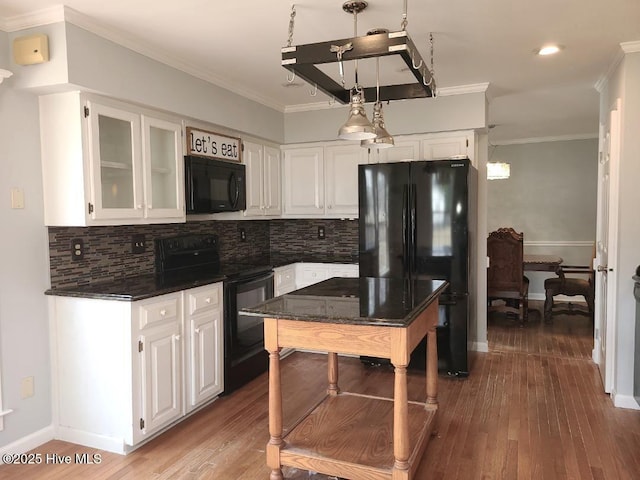 kitchen with black appliances, ornamental molding, backsplash, wood finished floors, and white cabinetry