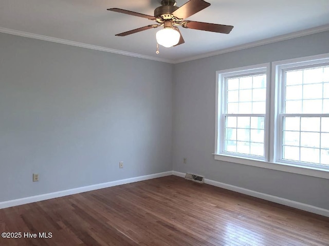 spare room featuring visible vents, baseboards, dark wood-style floors, and ornamental molding