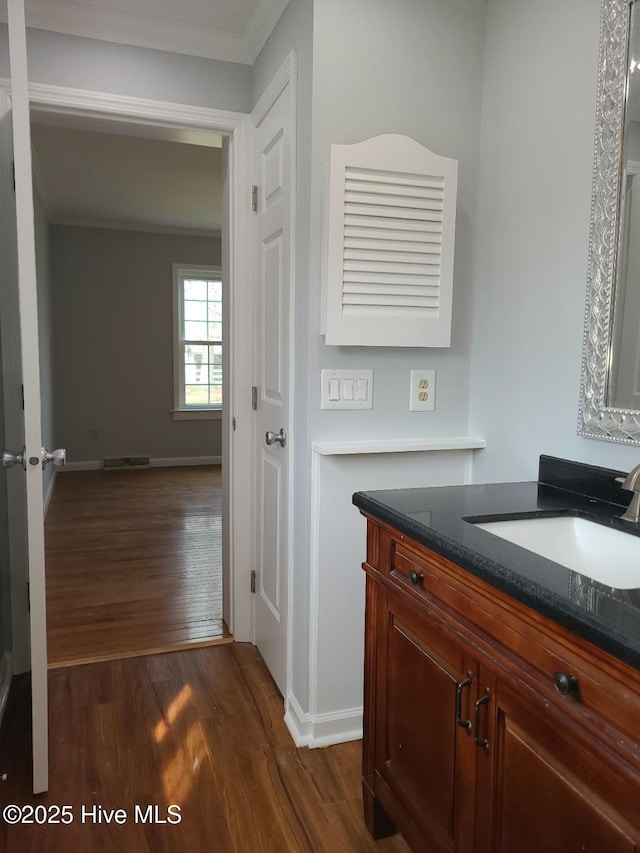 bathroom with vanity, wood finished floors, visible vents, and ornamental molding