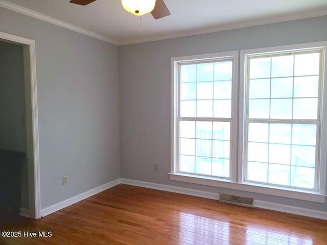 empty room featuring wood finished floors, visible vents, plenty of natural light, and ceiling fan