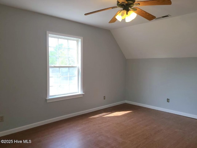 additional living space with lofted ceiling, wood finished floors, visible vents, and baseboards