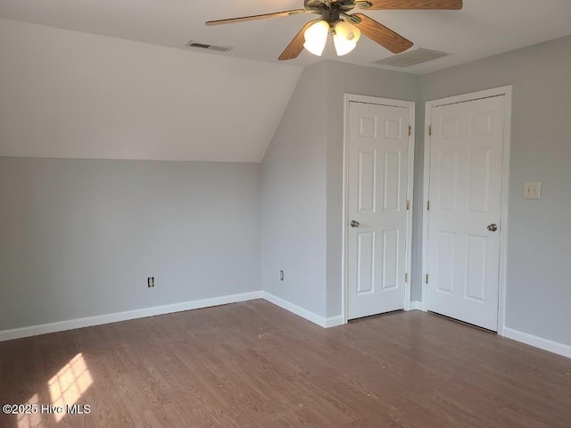 additional living space with visible vents, wood finished floors, baseboards, ceiling fan, and vaulted ceiling