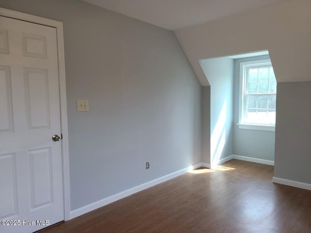 bonus room featuring dark wood-style floors and baseboards