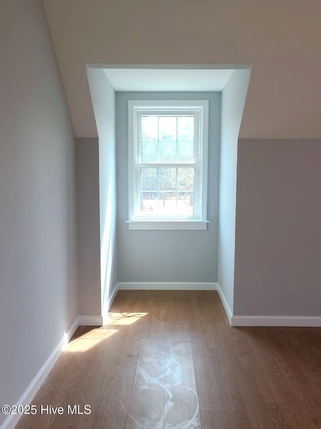 additional living space featuring wood finished floors and baseboards