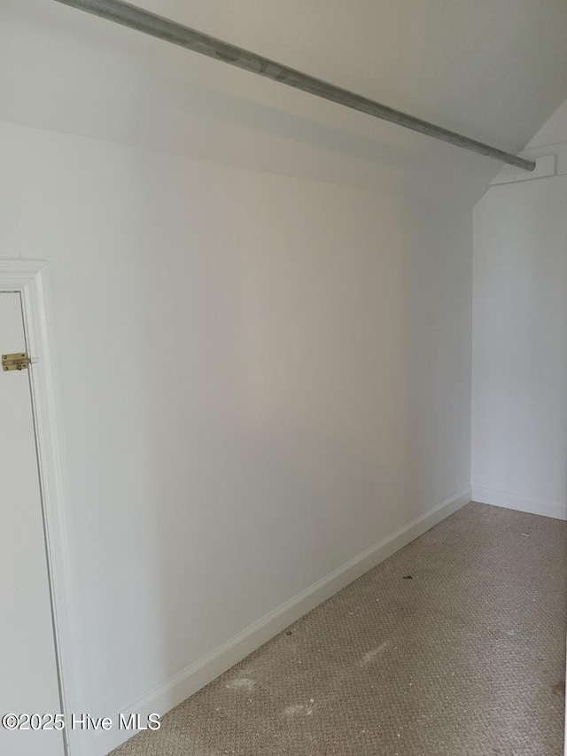 carpeted empty room featuring baseboards