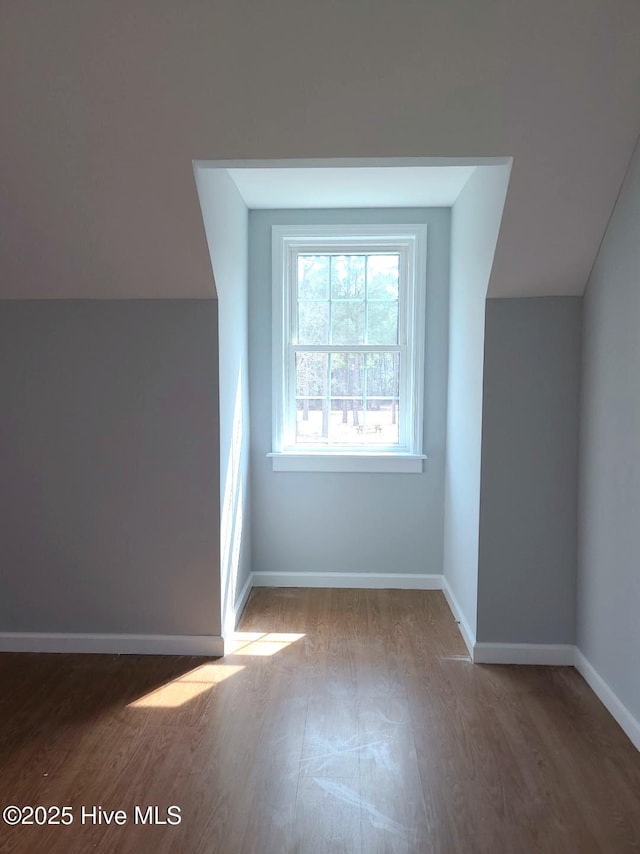 bonus room featuring lofted ceiling, wood finished floors, and baseboards