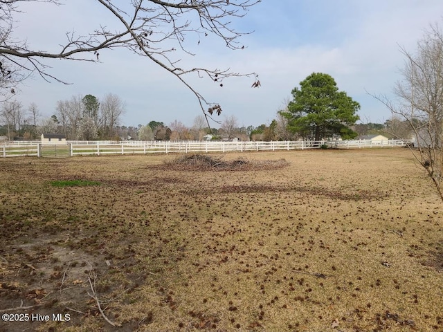 view of yard featuring a rural view, an enclosed area, and fence