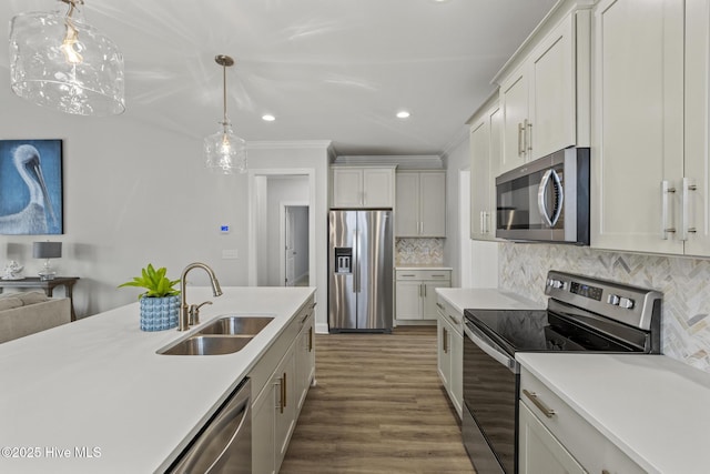 kitchen featuring light countertops, tasteful backsplash, appliances with stainless steel finishes, and a sink