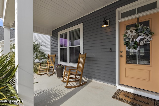 view of exterior entry featuring covered porch