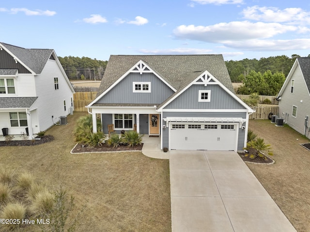 view of front of property with fence, an attached garage, a shingled roof, concrete driveway, and board and batten siding