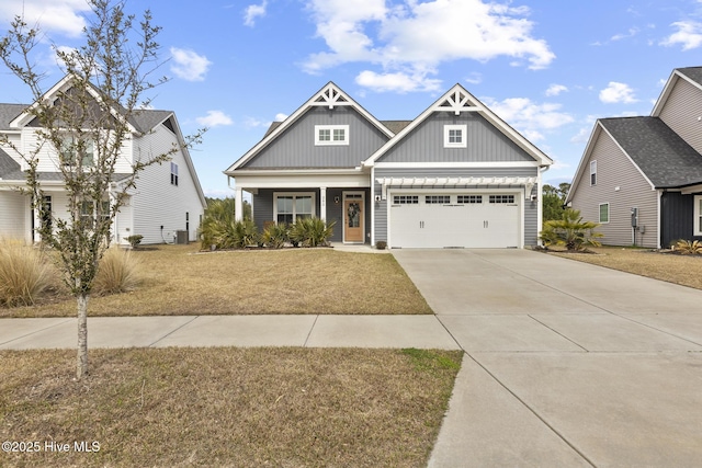 craftsman-style home with an attached garage, board and batten siding, a front yard, covered porch, and driveway