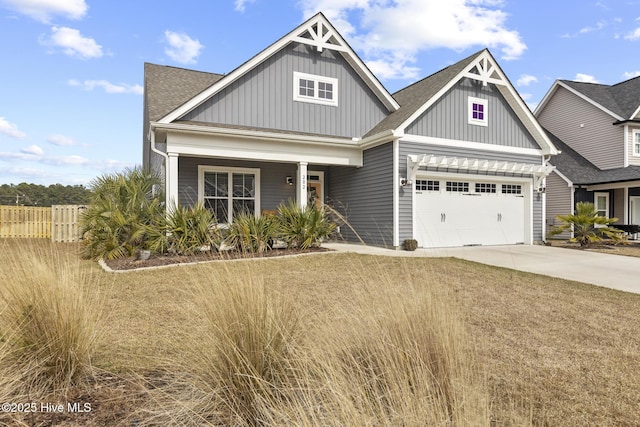 craftsman-style home featuring board and batten siding, a shingled roof, fence, concrete driveway, and a garage