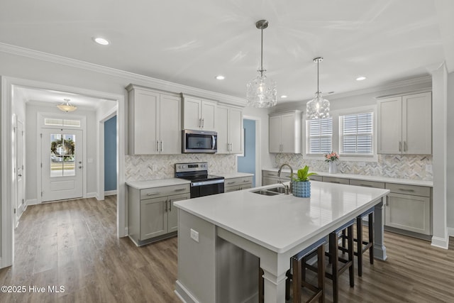 kitchen with a wealth of natural light, stainless steel appliances, light countertops, and a sink