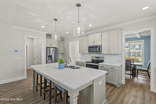 kitchen with a sink, backsplash, dark wood-style floors, stainless steel appliances, and a kitchen island with sink