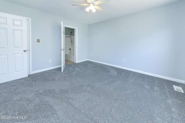 unfurnished bedroom featuring a textured ceiling, visible vents, dark colored carpet, and baseboards