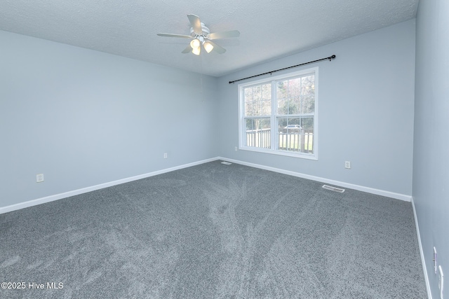 spare room featuring visible vents, baseboards, a textured ceiling, a ceiling fan, and dark colored carpet