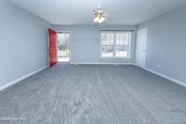 carpeted spare room featuring a ceiling fan and baseboards