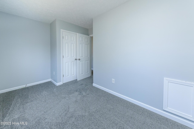 unfurnished bedroom with a closet, baseboards, carpet floors, and a textured ceiling