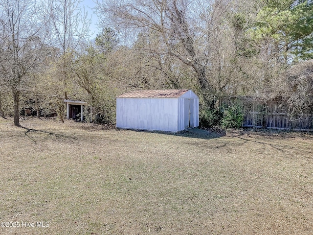 view of yard with fence, an outdoor structure, and a shed