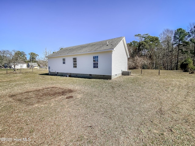 rear view of house with a shingled roof, a lawn, central AC, and crawl space