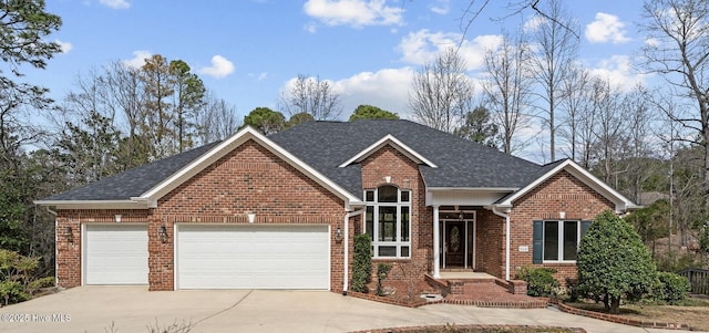 view of front of house featuring a garage, brick siding, roof with shingles, and driveway