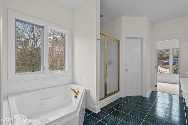 bathroom with tile patterned floors, a jetted tub, baseboards, and a stall shower