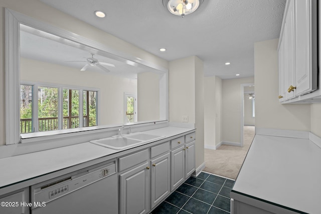 kitchen featuring dishwashing machine, light countertops, and a sink