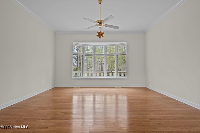 empty room with baseboards, wood finished floors, ceiling fan, and ornamental molding