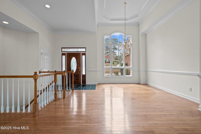 entryway featuring baseboards, ornamental molding, hardwood / wood-style floors, recessed lighting, and a notable chandelier