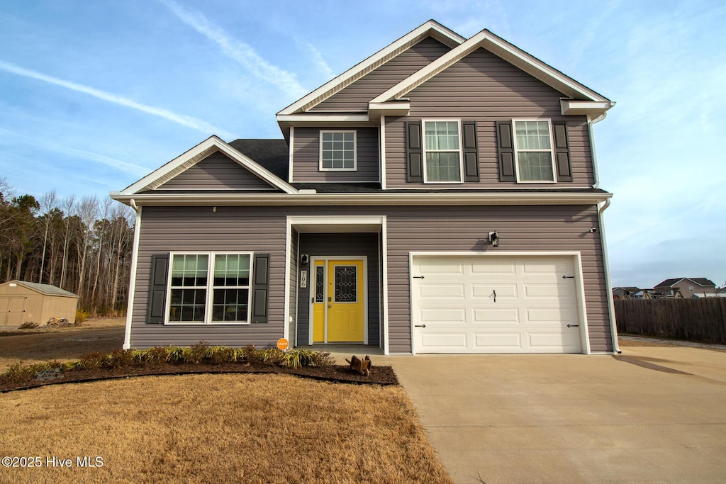 traditional-style home with fence, a garage, and driveway