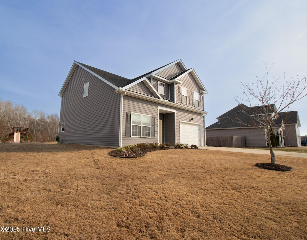 traditional-style house featuring a front yard and an attached garage