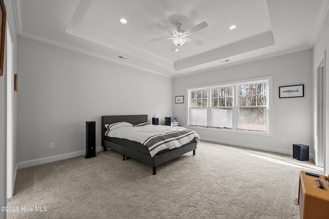 carpeted bedroom with baseboards, a tray ceiling, recessed lighting, ceiling fan, and crown molding