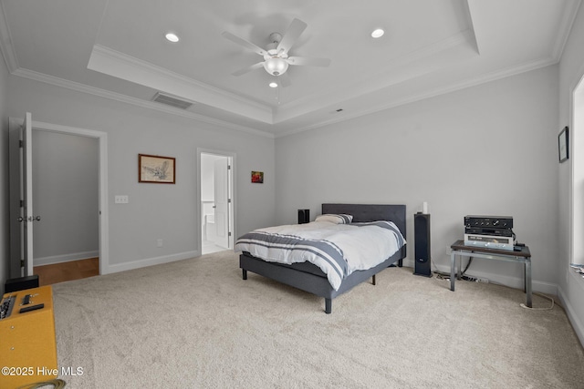 carpeted bedroom with visible vents, a raised ceiling, baseboards, and crown molding